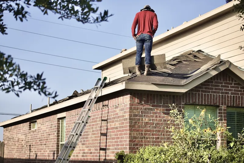 Professional roofer working on a residential roof in Penwell